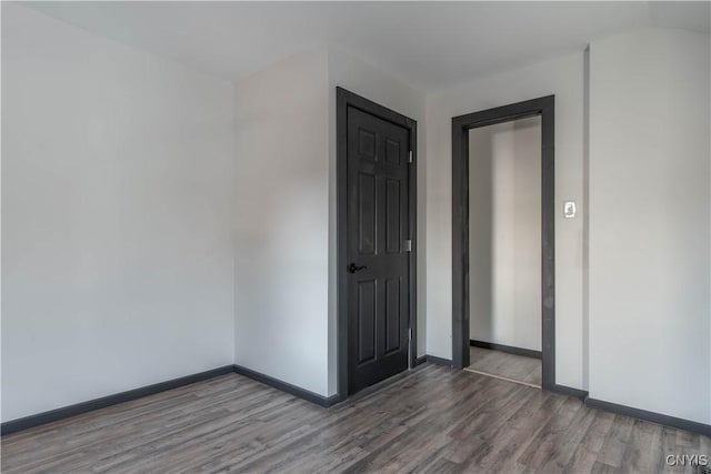 spare room featuring wood finished floors and baseboards