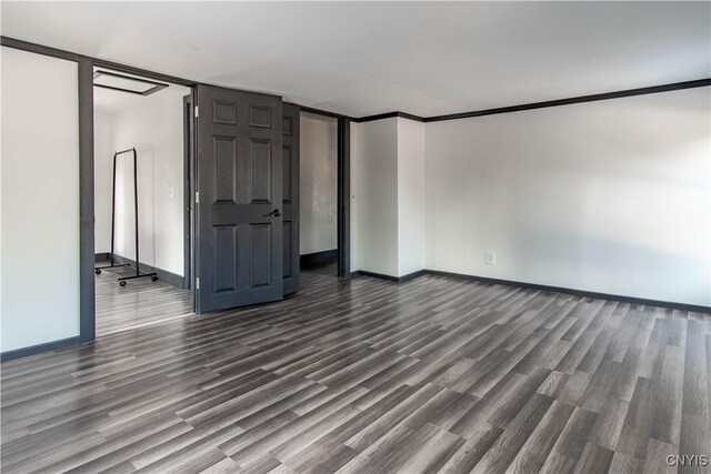 unfurnished room with baseboards and dark wood-type flooring