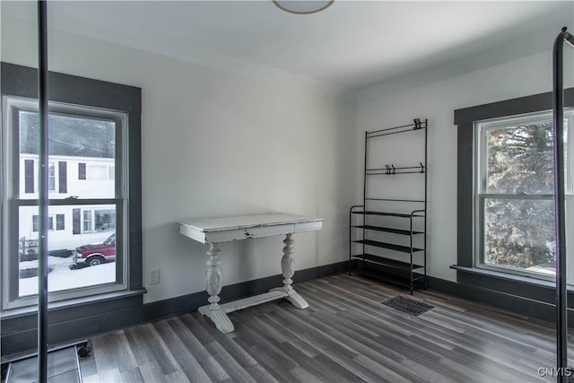 interior space featuring visible vents, baseboards, and dark wood-style floors