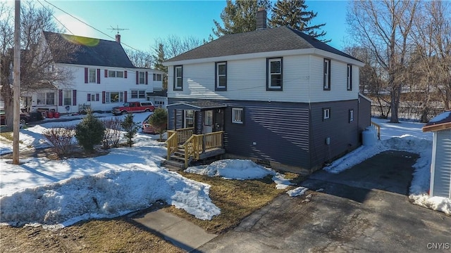 view of front facade with aphalt driveway and a chimney