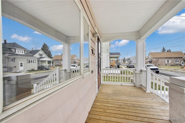 wooden terrace featuring a residential view and covered porch