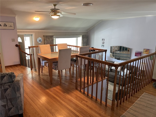 dining space featuring visible vents, a healthy amount of sunlight, lofted ceiling, and wood finished floors