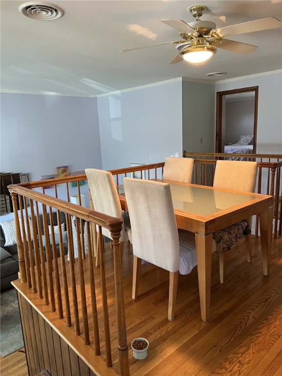 dining room with visible vents, light wood-style flooring, and ornamental molding