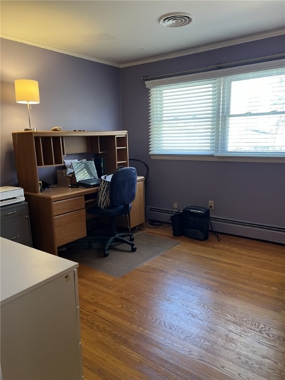 office featuring visible vents, ornamental molding, a baseboard heating unit, wood finished floors, and baseboard heating