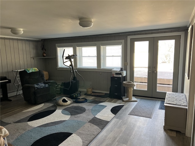 exercise room featuring a baseboard heating unit, wood finished floors, and french doors