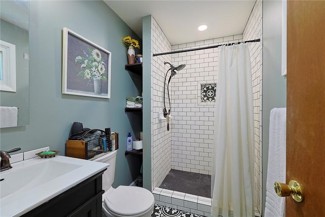 bathroom with a shower stall, toilet, and vanity