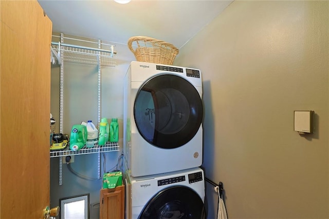 washroom featuring stacked washer and dryer and laundry area