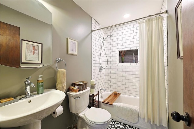 full bathroom featuring toilet, shower / bath combo with shower curtain, and a sink