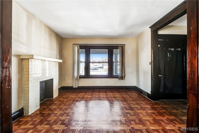 unfurnished living room featuring a fireplace and baseboards