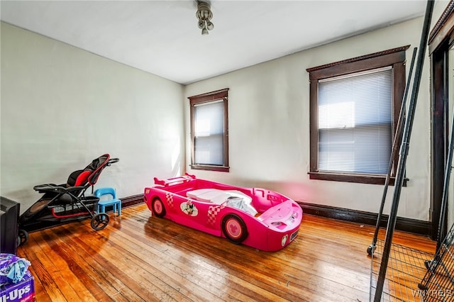 bedroom with baseboards and hardwood / wood-style flooring