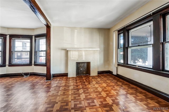 unfurnished living room featuring a fireplace and baseboards