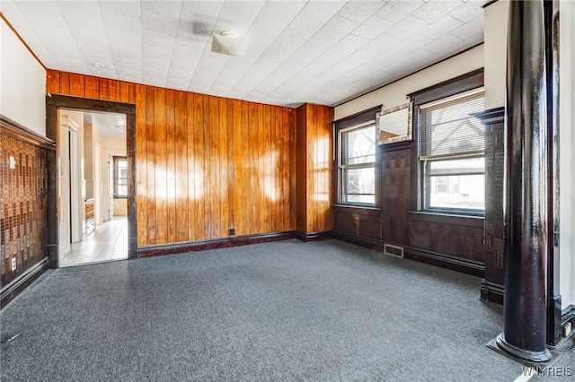 empty room with visible vents and wood walls