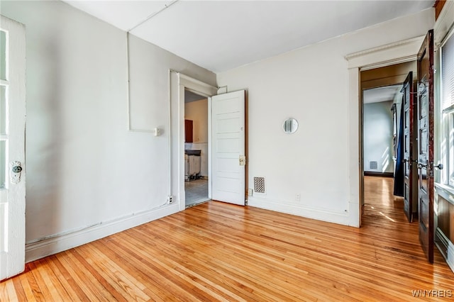 unfurnished bedroom featuring visible vents, wood-type flooring, and baseboards