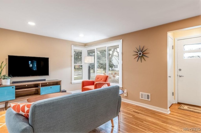 living room featuring recessed lighting, wood finished floors, visible vents, and baseboards