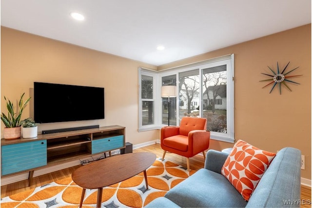 living area featuring recessed lighting, baseboards, and wood finished floors