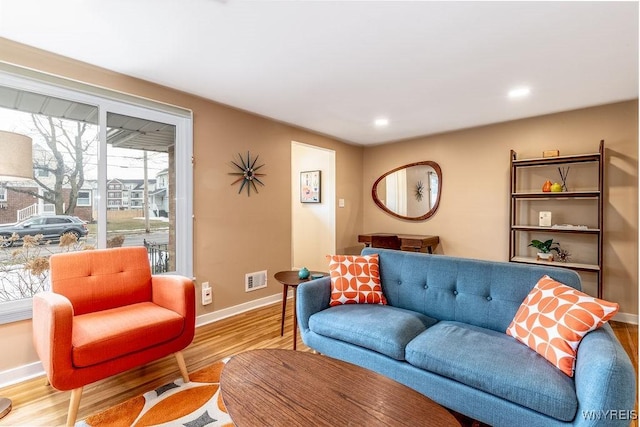 living area with visible vents, recessed lighting, baseboards, and wood finished floors