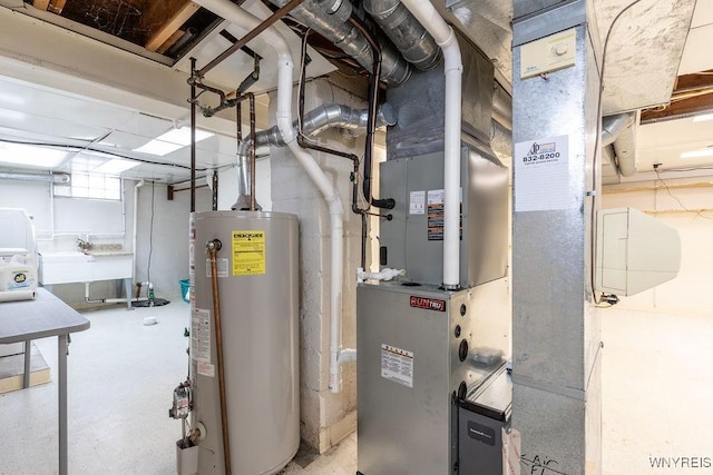 utility room featuring gas water heater and a sink