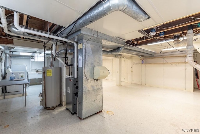 basement with a sink, heating unit, and water heater