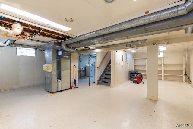 basement with heating unit, washer / dryer, and stairs