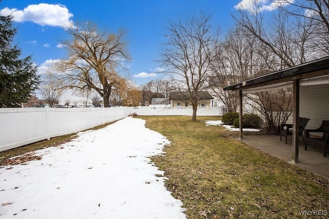 snowy yard with a patio area and fence