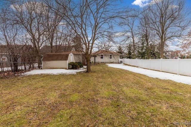 view of yard with an outbuilding, a storage unit, and a fenced backyard