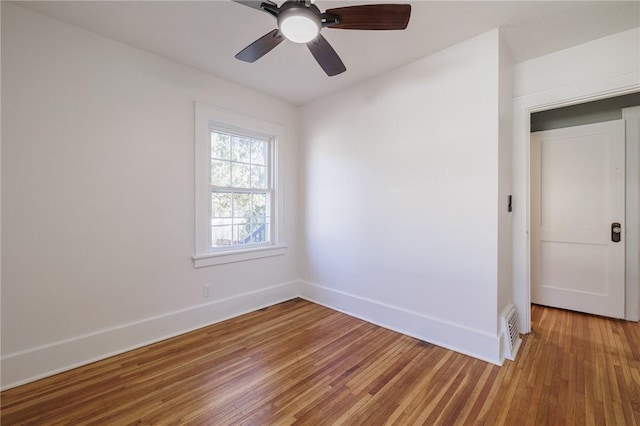 spare room with visible vents, ceiling fan, light wood-type flooring, and baseboards