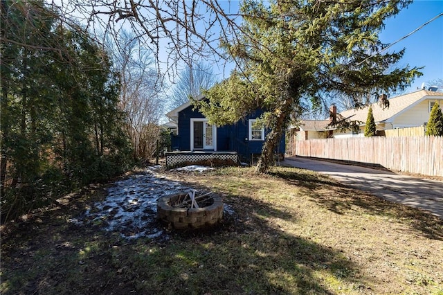 view of yard with fence and an outdoor fire pit