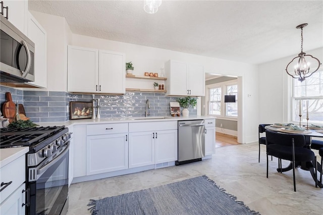 kitchen featuring a sink, appliances with stainless steel finishes, white cabinets, and light countertops