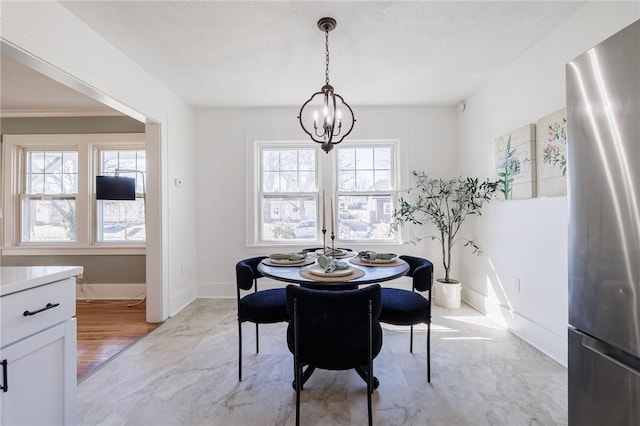 dining area featuring baseboards, a notable chandelier, and marble finish floor