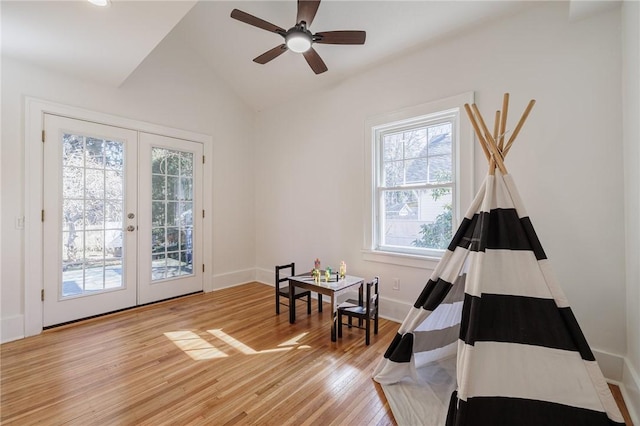 interior space with vaulted ceiling, french doors, baseboards, and light wood finished floors