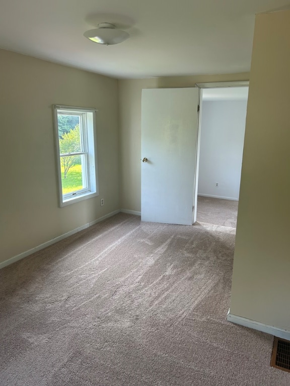 unfurnished room featuring visible vents, baseboards, and carpet floors