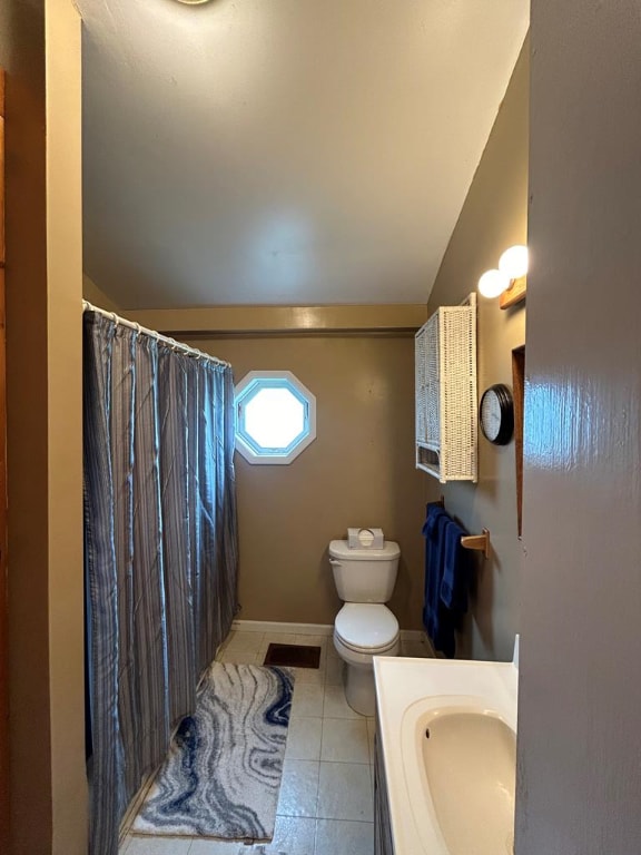 full bathroom featuring toilet, a shower with shower curtain, tile patterned flooring, vanity, and vaulted ceiling