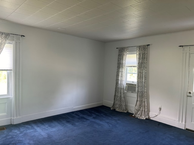 unfurnished room with dark colored carpet, cooling unit, and baseboards