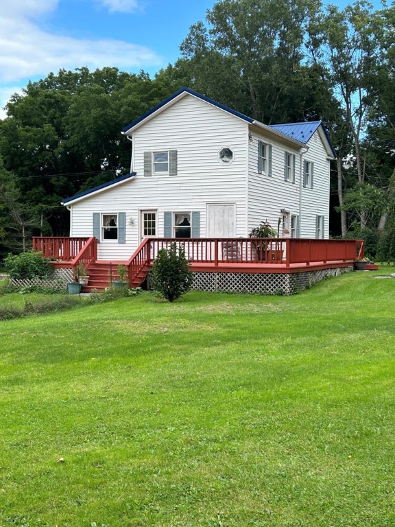 rear view of house with a yard and a wooden deck