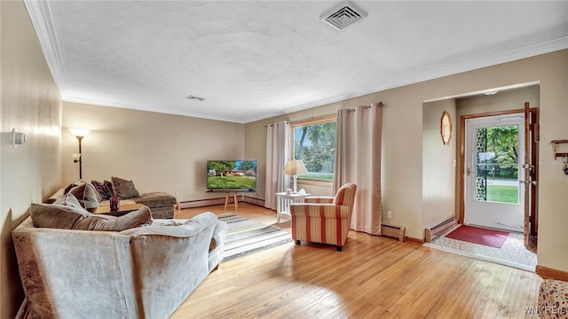 living room with a wealth of natural light, visible vents, baseboard heating, and light wood-style floors