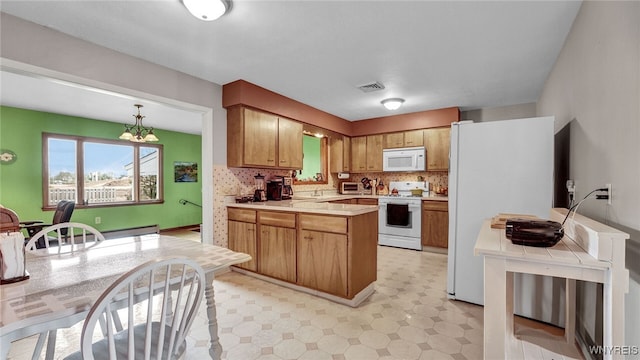 kitchen featuring tasteful backsplash, light floors, light countertops, a peninsula, and white appliances