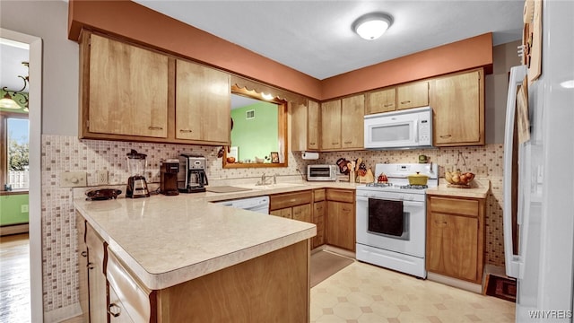 kitchen featuring backsplash, light floors, light countertops, a peninsula, and white appliances