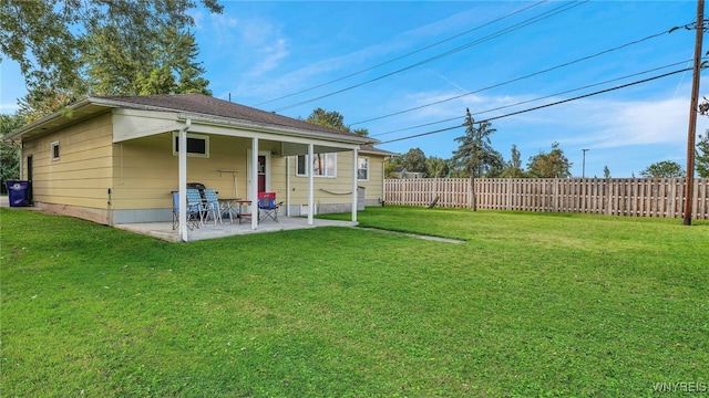 back of house featuring a patio area, a yard, and fence