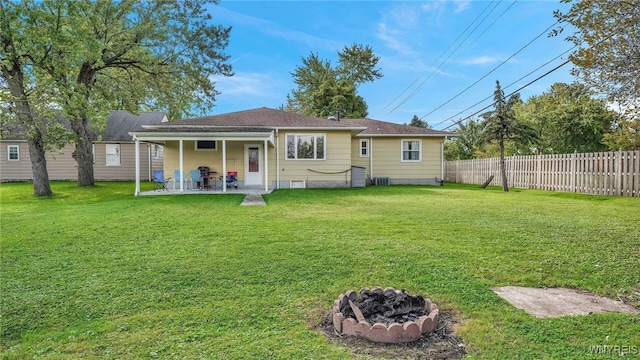 rear view of house featuring a patio, fence, a lawn, and an outdoor fire pit