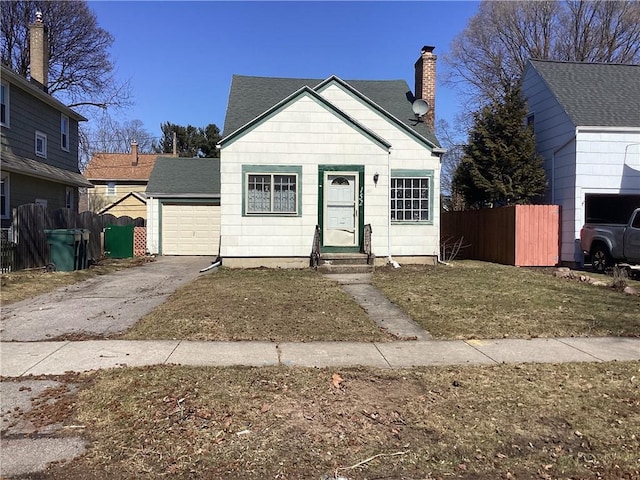 bungalow with fence, a garage, driveway, and a chimney