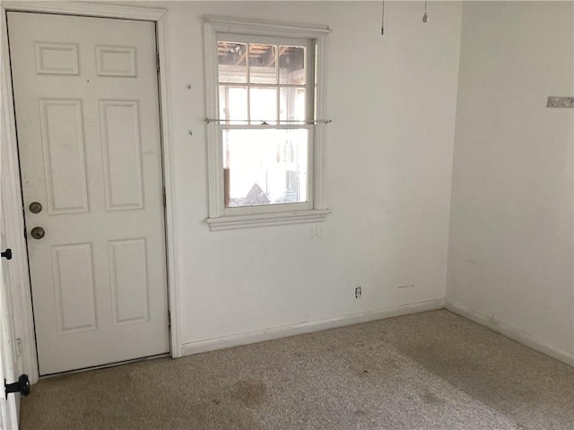 empty room featuring baseboards and carpet floors