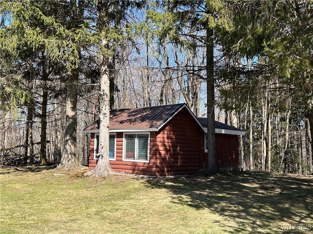 view of property exterior featuring log veneer siding and a lawn