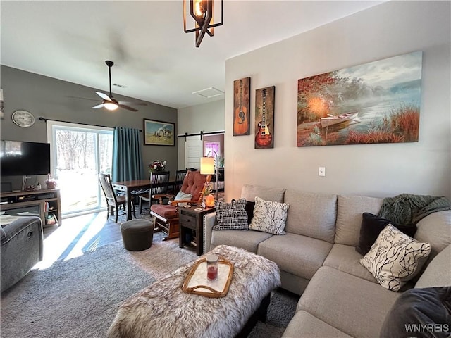 living room featuring a barn door, carpet floors, visible vents, and a ceiling fan