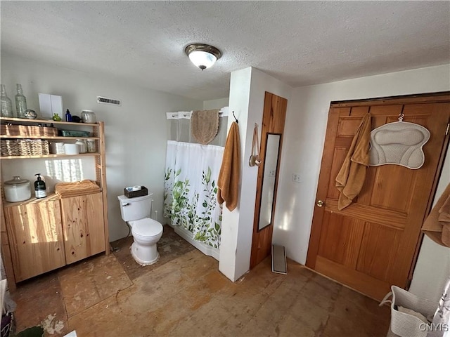 bathroom with visible vents, a textured ceiling, and toilet