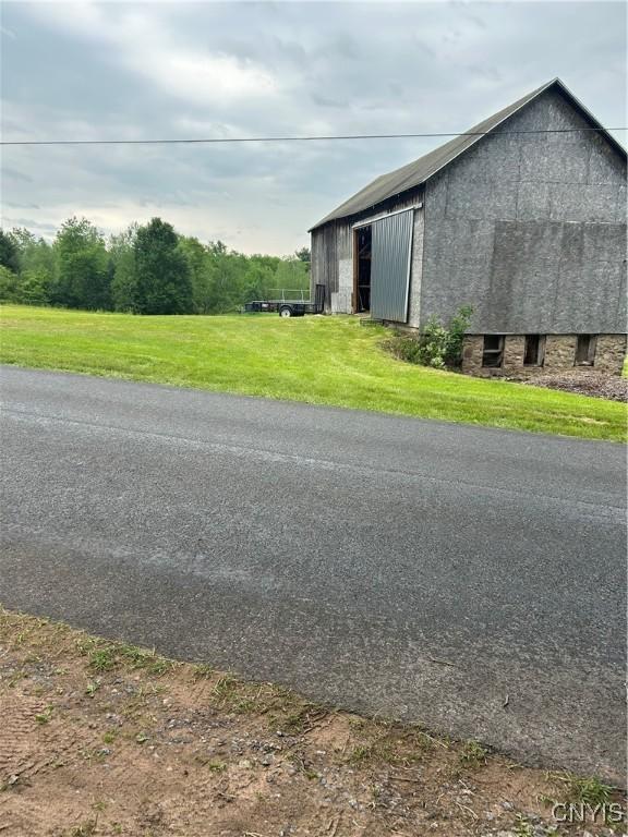 view of side of home with a yard, an outbuilding, and an outdoor structure