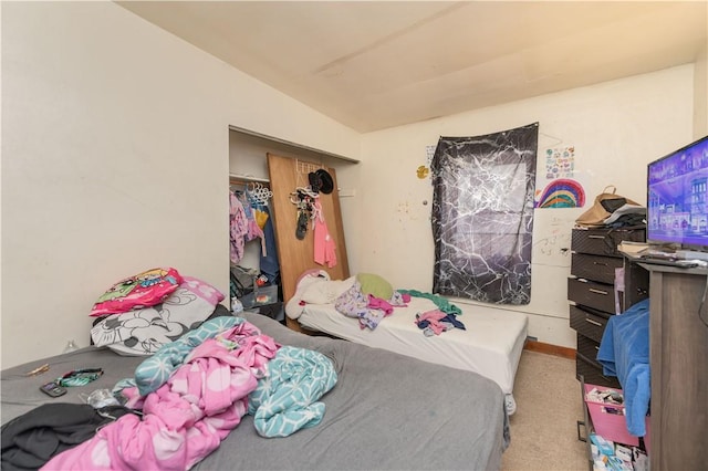 bedroom featuring a closet, vaulted ceiling, and carpet floors