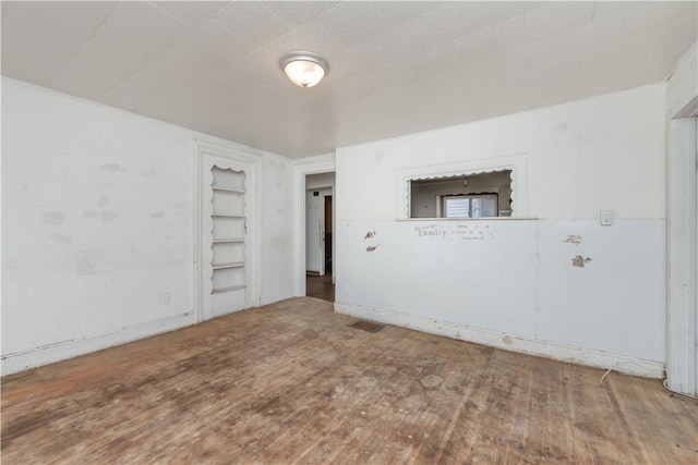 empty room featuring visible vents and wood finished floors