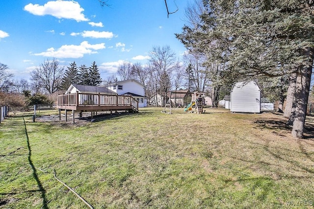 view of yard featuring fence, a deck, and a playground