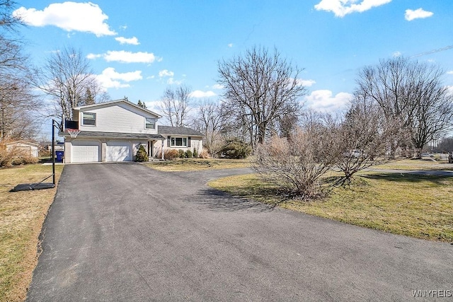 view of front facade featuring aphalt driveway, an attached garage, and a front yard