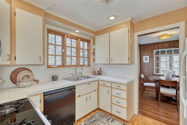 kitchen featuring a sink, black appliances, a wealth of natural light, and ornamental molding